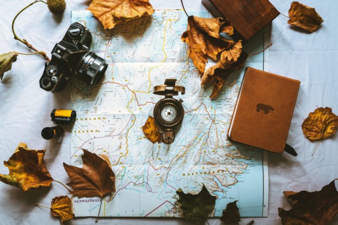 aerial view of map, camera, compass and notebook