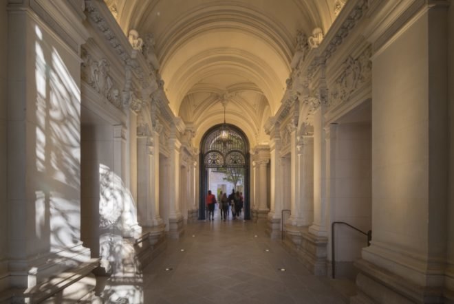 group of people walk through hallway