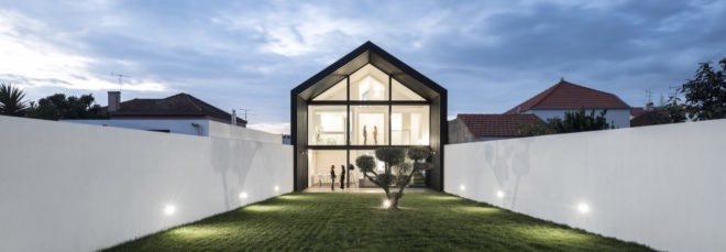 black and white home with glass wall and gabled roof