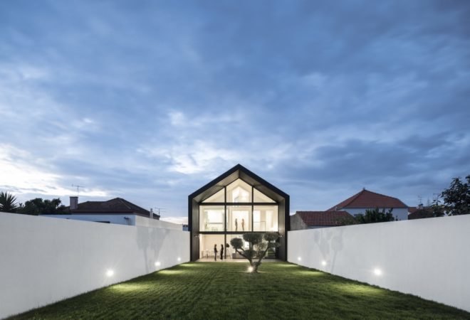 black and white home with glass wall and gabled roof