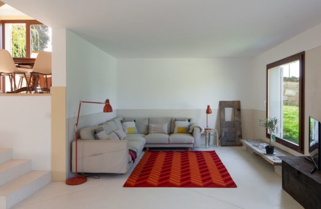 white room with sofa and red and orange rug