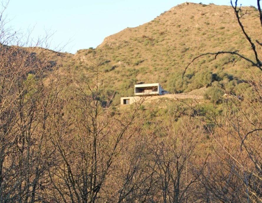 a rectangular home surrounded by mountainside