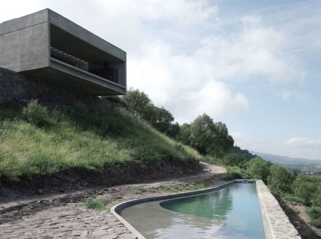 a rectangular home looking out over a small pool