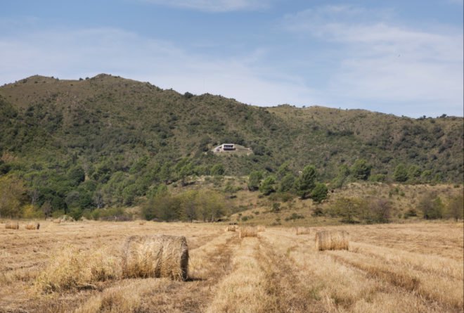 a rectangular home surrounded by a mountainside