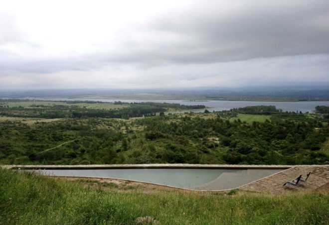 a small swimming pool surrounded by natural landscape