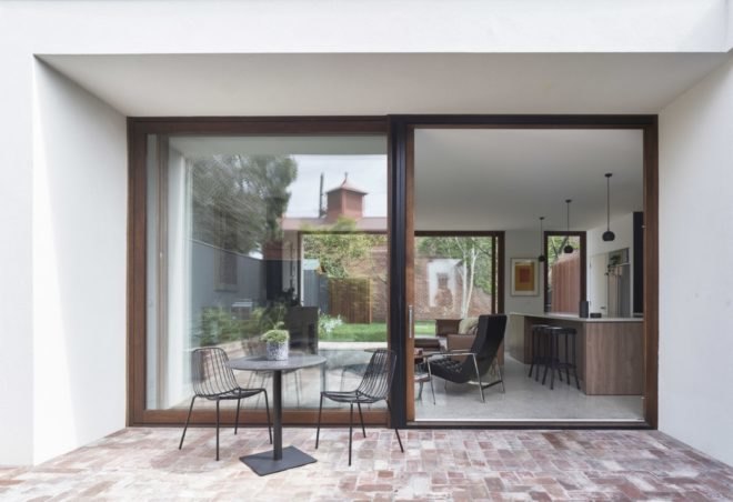 patio furniture on the outside of the home with views of the living area through large windows