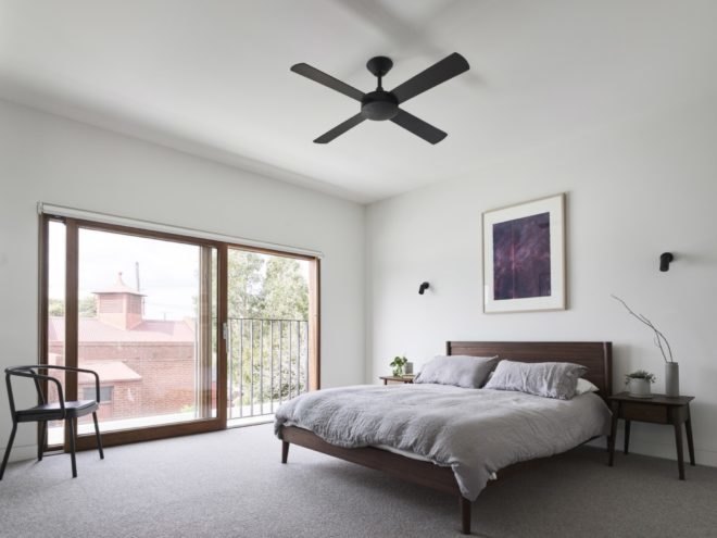 bedroom filled with sunlight from large glass screen door