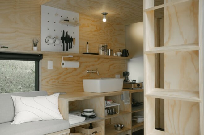 long wooden sofa and kitchen area inside tiny cabin