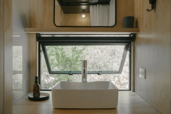 white sink sitting in front of open window