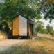 black tiny cabin on gravel path