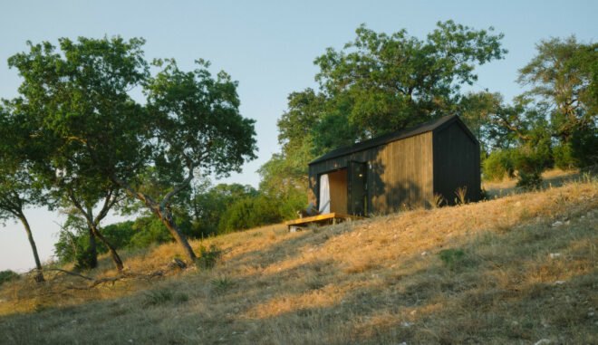 Black tiny cabin on hilltop