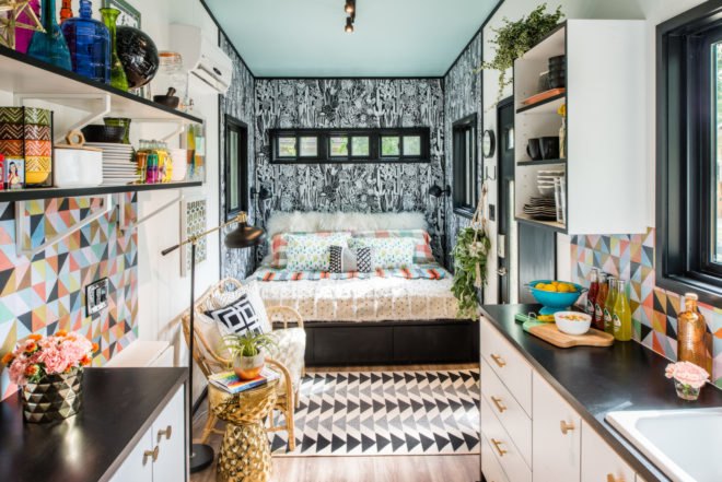 tiny home interior with black and white wallpaper, patterned rug and bold colors everywhere