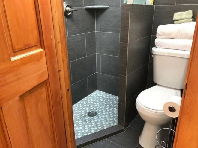 A grey bathroom with shower and toilet