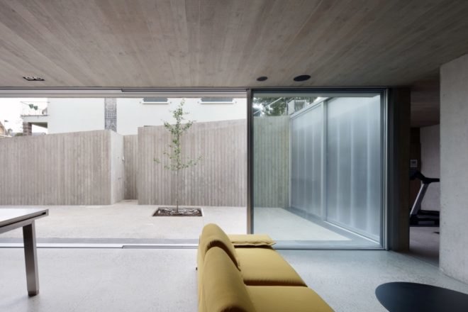 gray room with yellow couch opening to patio through sliding glass doors