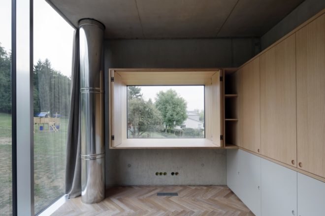 gray room with chevron wood floors and a large window open to the outdoors