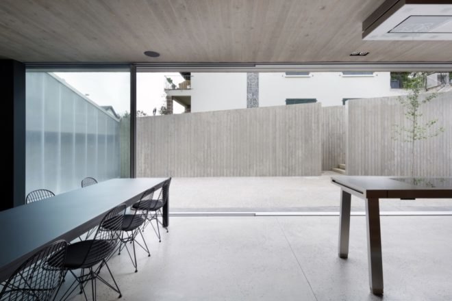gray room with long dining table facing an open patio