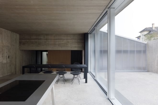 gray room with long black dining table near glass wall