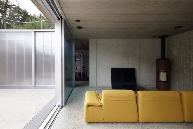 yellow couch in a gray room with a wood-burning stove