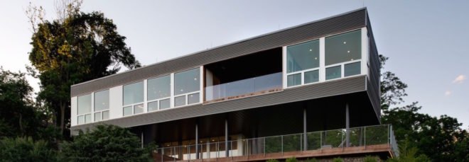 elevated gray home with large windows