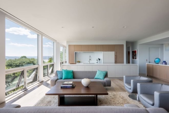 open-plan living area with gray couches and white kitchen
