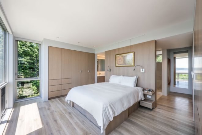 bedroom with white bed and light wood walls