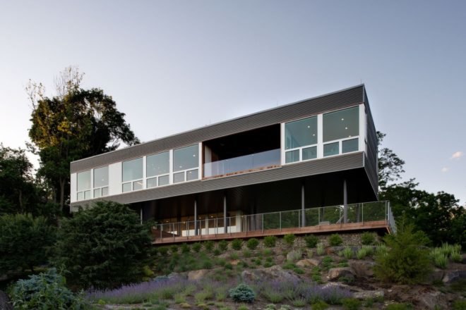 elevated gray home with large windows