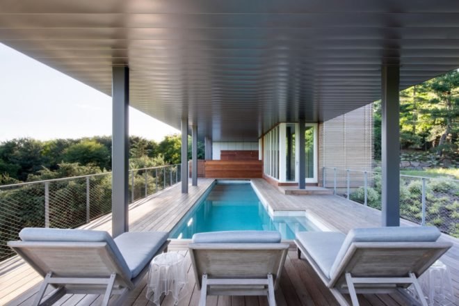 lounge chairs facing a narrow swimming pool