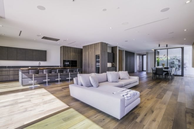 wood floors throughout the home's base floor with big windows letting in light towards the kitchen and living room