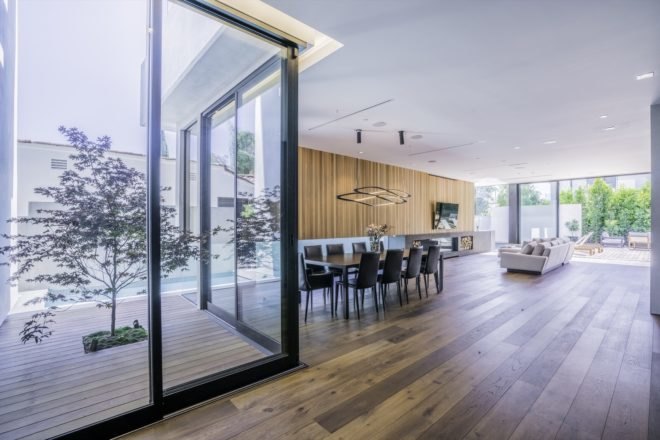 floor to ceiling windows are placed on opposite ends of the home letting in light to dining and living room
