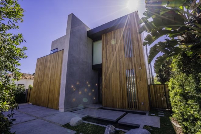 exterior view of the home's entrance with wood finishing and modern cement design on entrance floor