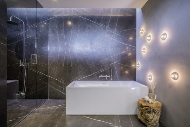 modern white tub in the bathroom with shower space beside it