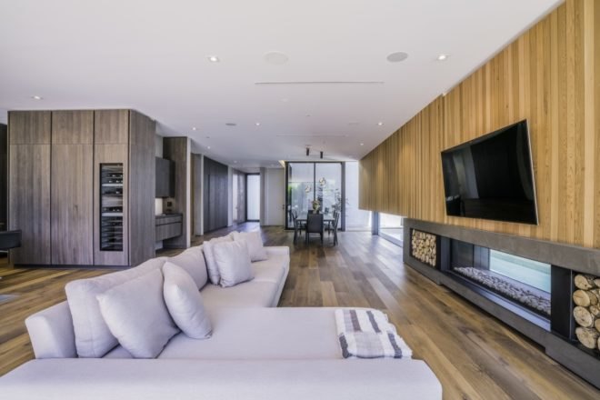 living room with wood floors, flat screen tv and white couch leading into dining room