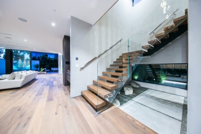 stair case with wood steps and glass rails