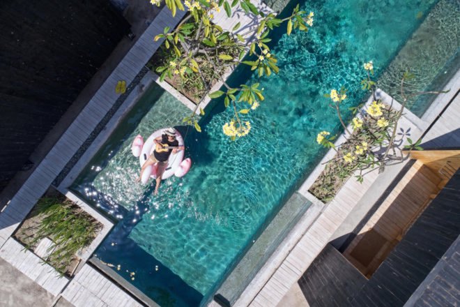 aerial shot of woman on a float in a pool