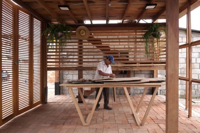 person working on a wood table inside a wood building
