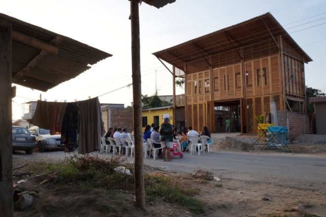 people gathered outside large wood building