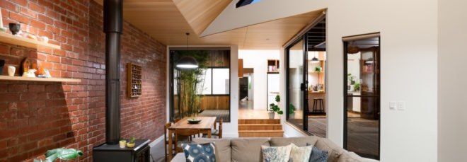 living room with exposed brick wall and tan sectional sofa