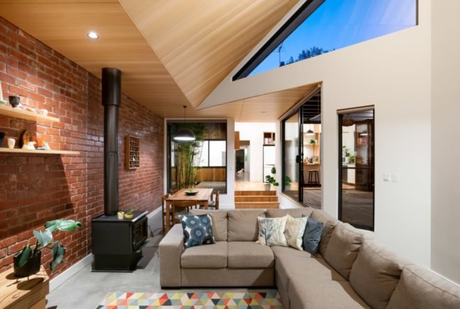 living room with exposed brick wall and tan sectional sofa