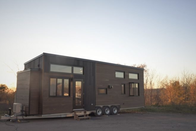 a wooden tiny home on wheels with windows