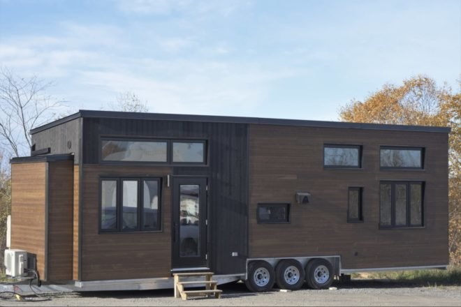 a wooden tiny home on wheels with windows