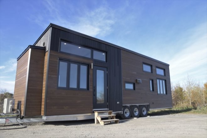 a wooden tiny home on wheels with windows