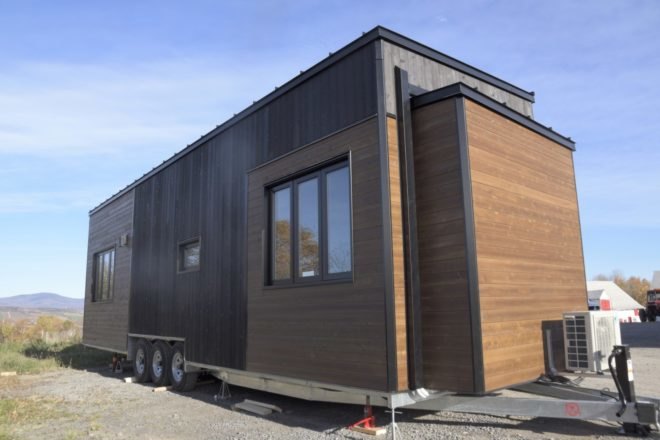 a wooden tiny home on wheels with windows
