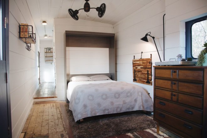 bedroom with all white walls and wooden furnishings