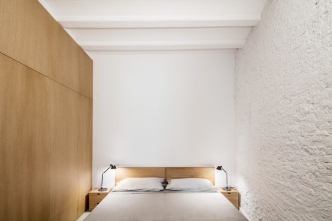 bedroom with bed and stone walls painted white