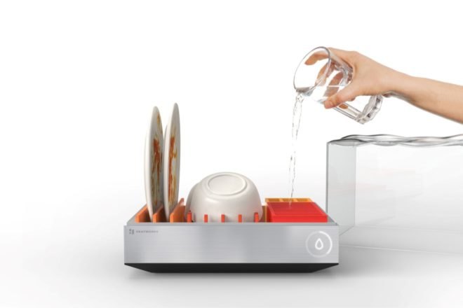 person loading dishes into small dishwasher