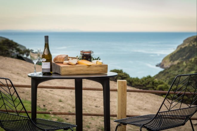 small table with bottle of wine and tray of snacks