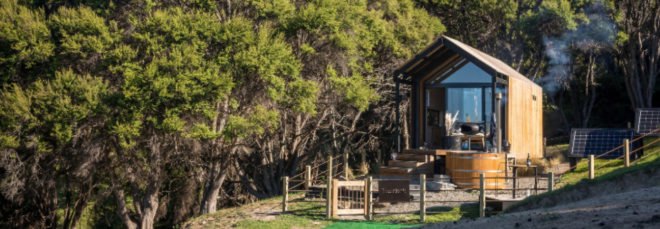 Tiny home with pitched roof and glass facade