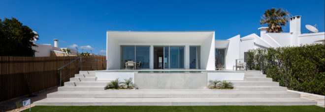 white cube-like building with glass facade
