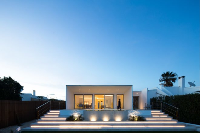 white cube-like building in front of stairs