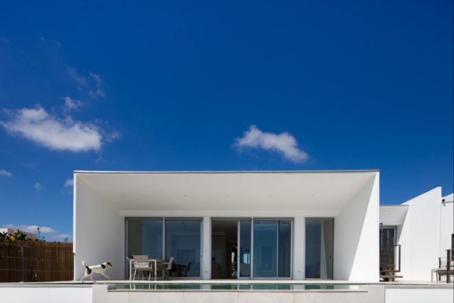 white cube-like building with glass facade